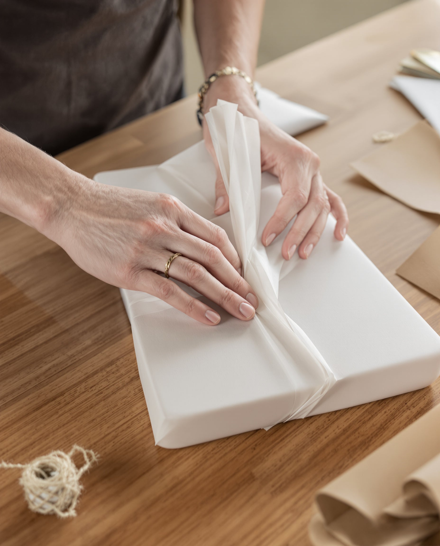 Mains qui emballent une planche dans du papier de soie avant expédition